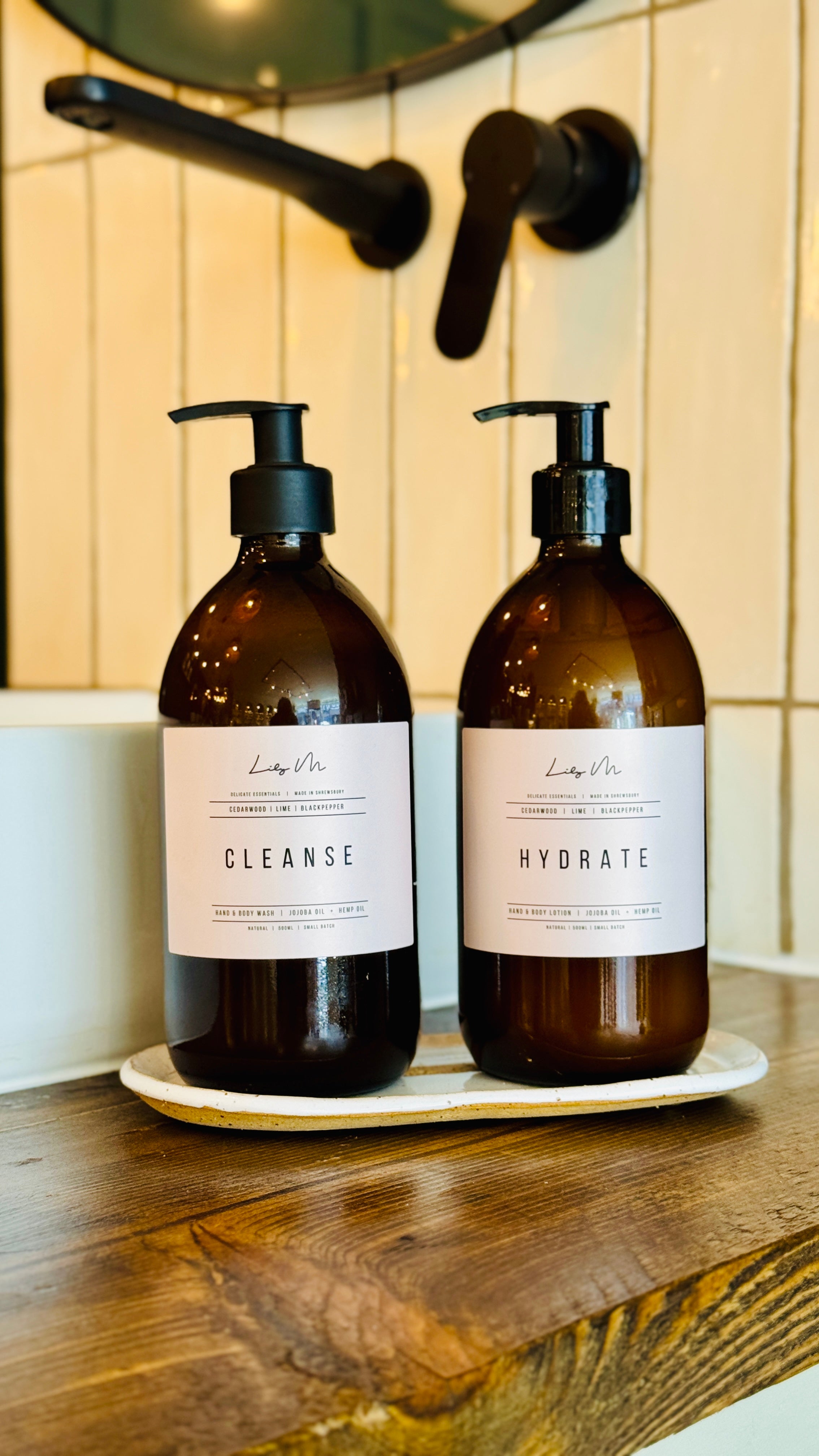 Cedarwood lime & Black pepper hand & Body lotion and Hand & Body wash together on a handmade stoneware bottle holder tray