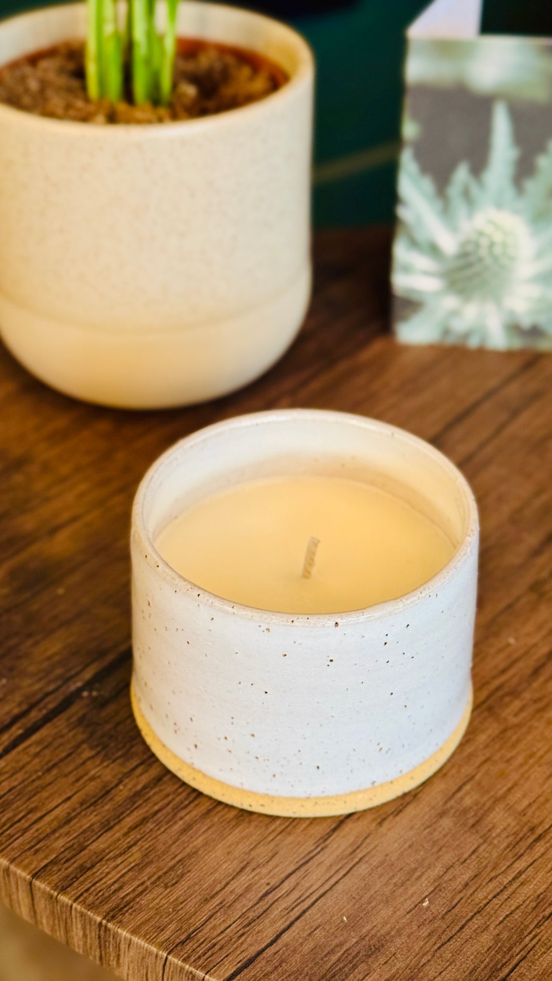 handmade white glaze candle jar on a small wooden table