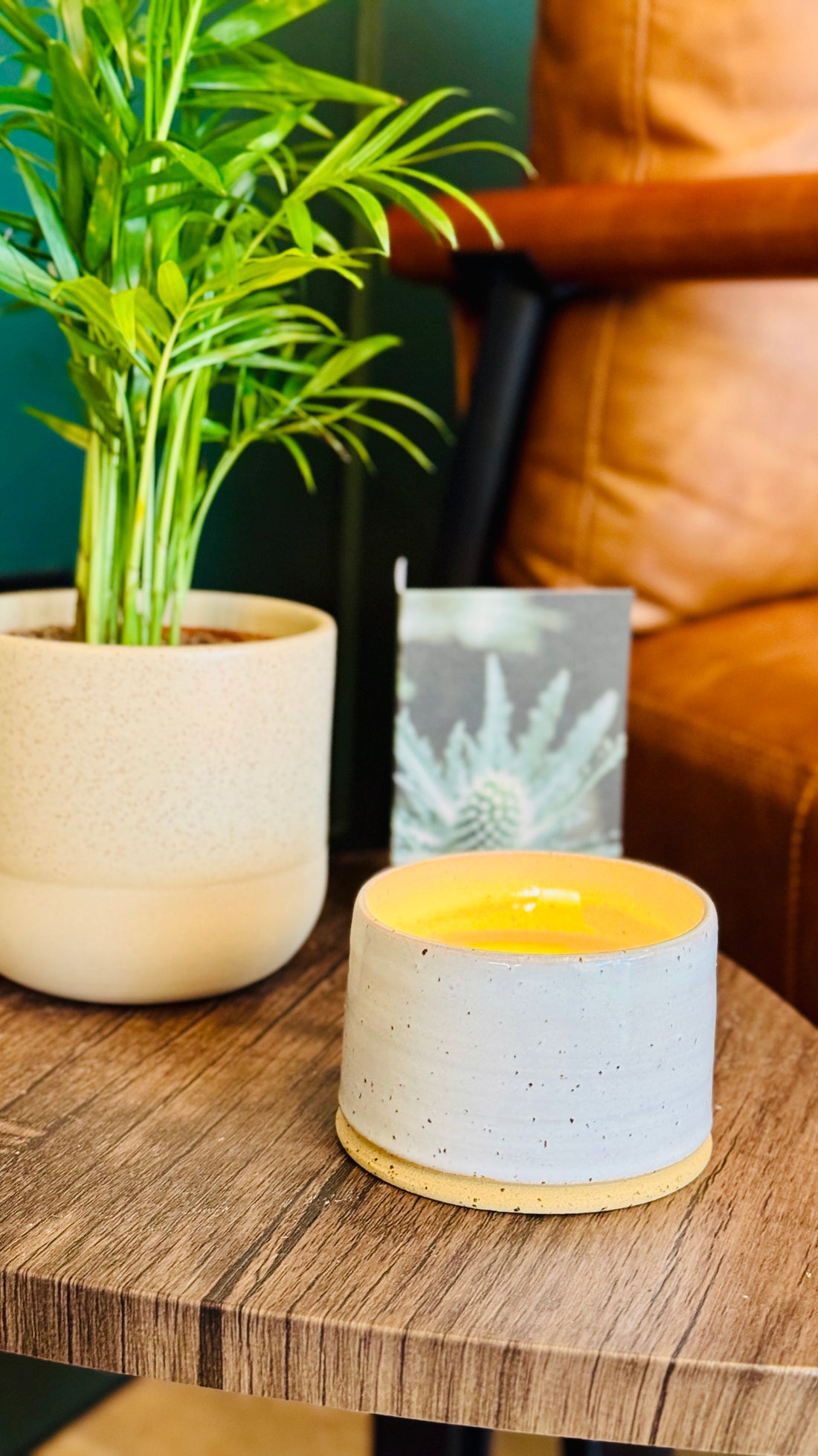 handmade white glaze candle jar on a small wooden table