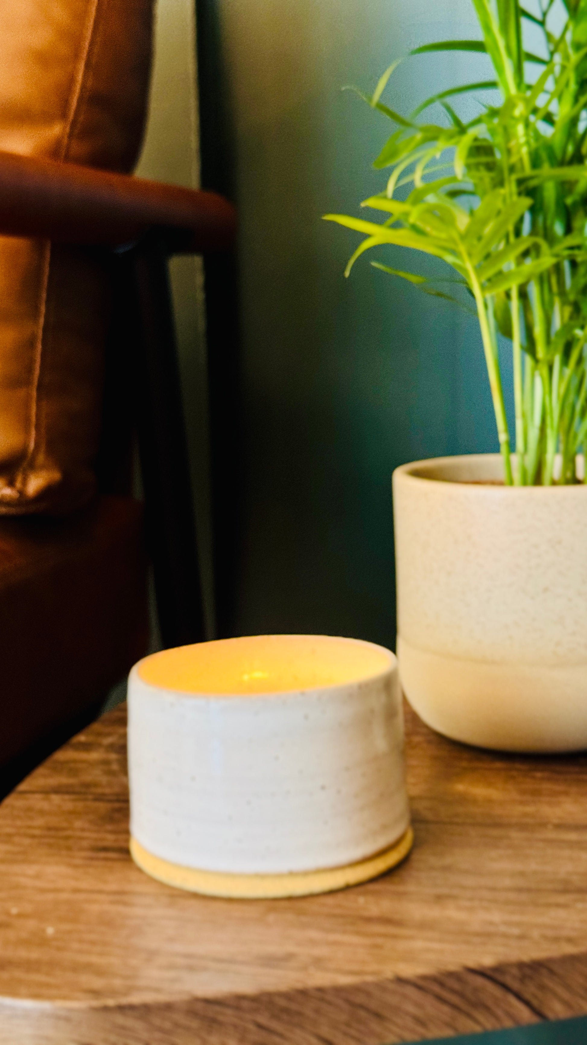handmade white glaze candle jar on a small wooden table