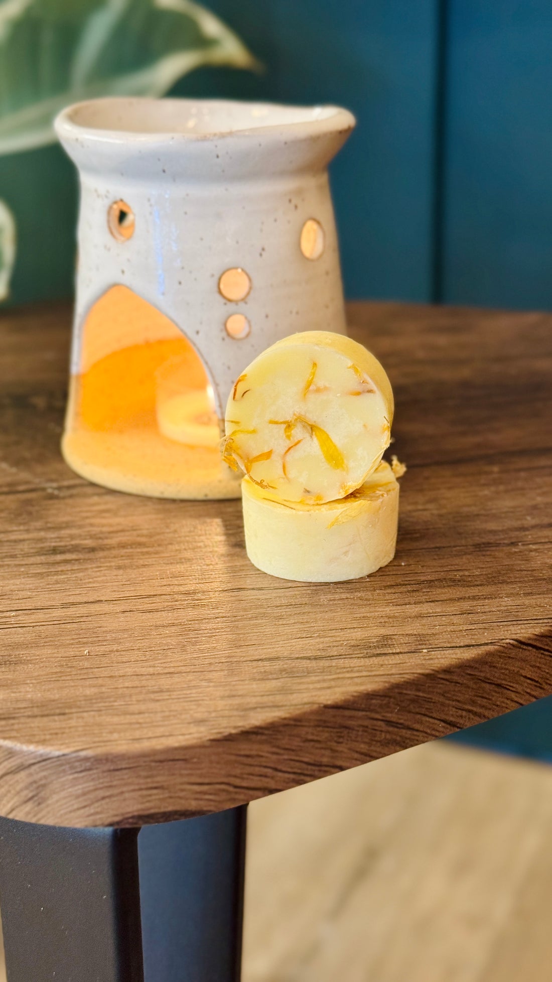 essential oil mandarin & Marjoram wax melts with the burner behind on a wooden table