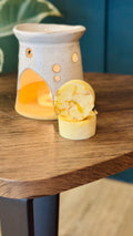 essential oil mandarin & Marjoram wax melts with the burner behind on a wooden table