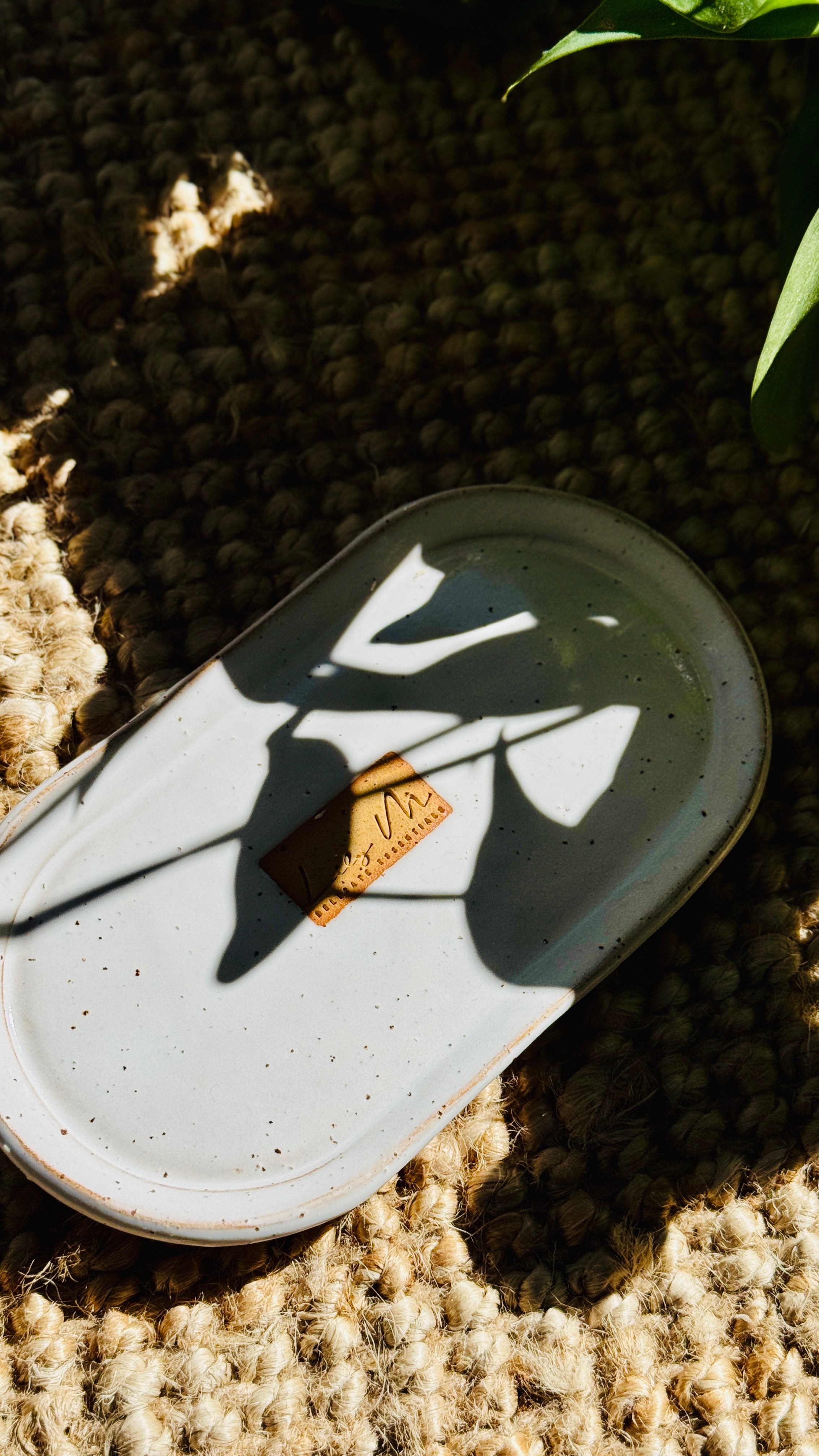 hand wash bottle tray on a hessian rug with a plant shadow covering it, Lily M logo stamped in the the center of the tray