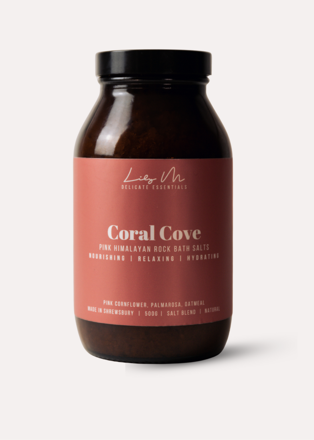 Bottle of Coral Cove bath salts with a pink label on a white background