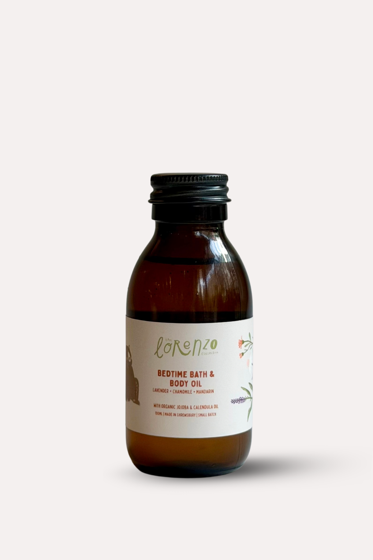 A small amber glass bottle of Lorenzo Bedtime Bath & Body Oil with a black cap and a cream label, centered on a light gray background.