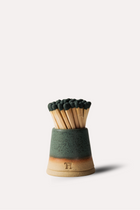 Matches in a green and wooden holder on a white background