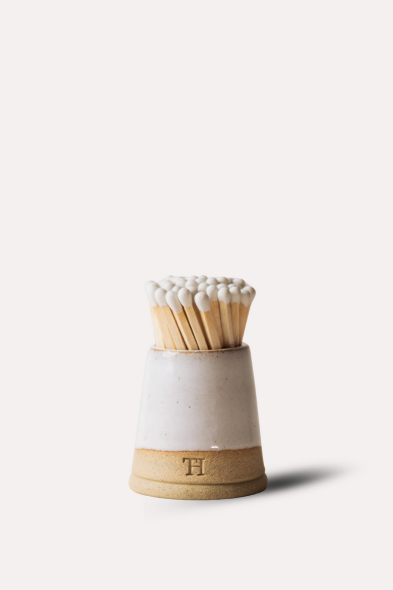 Matches in a ceramic holder on a white background
