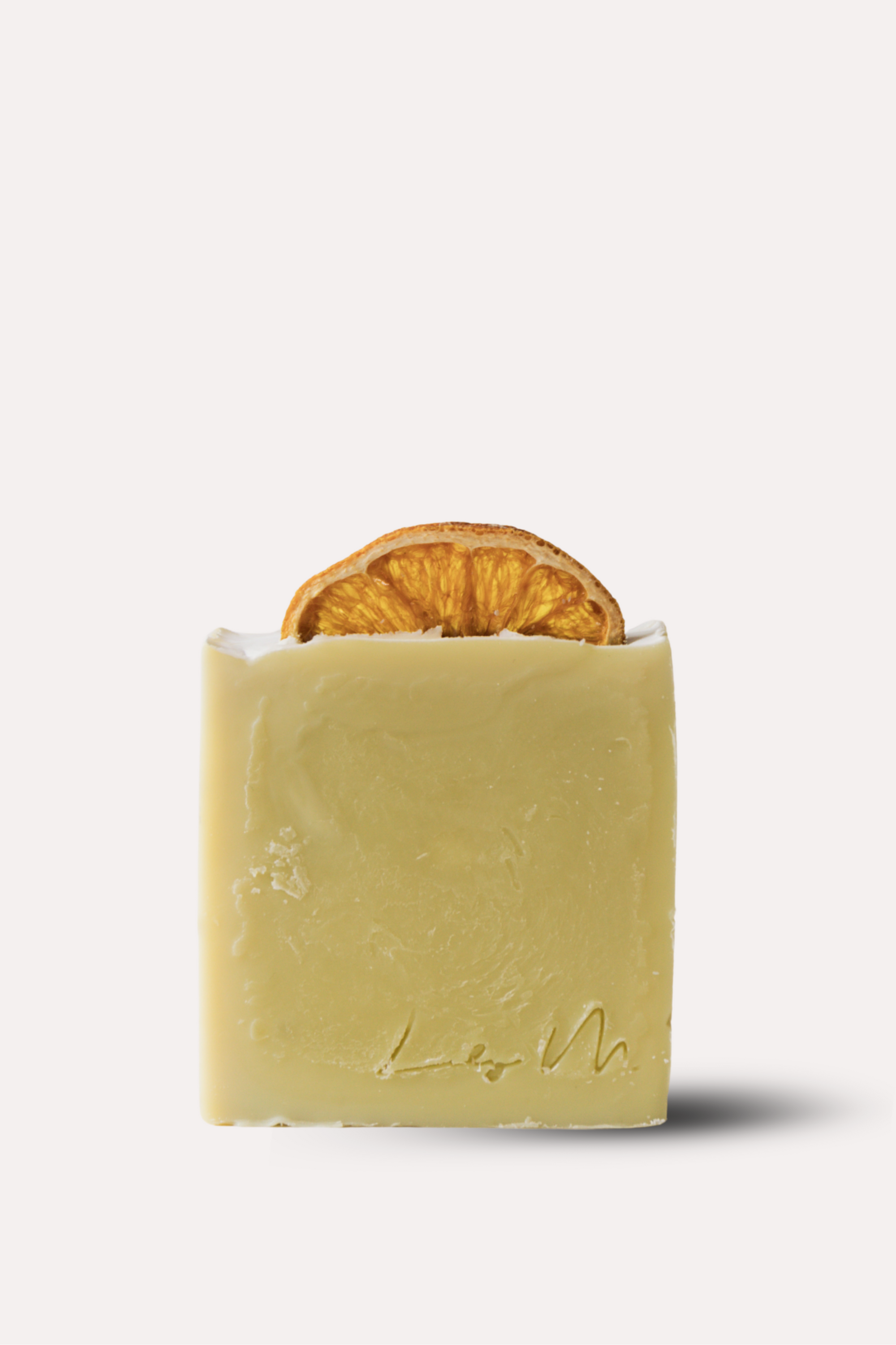 Bar of soap with a slice of orange inside on a white background