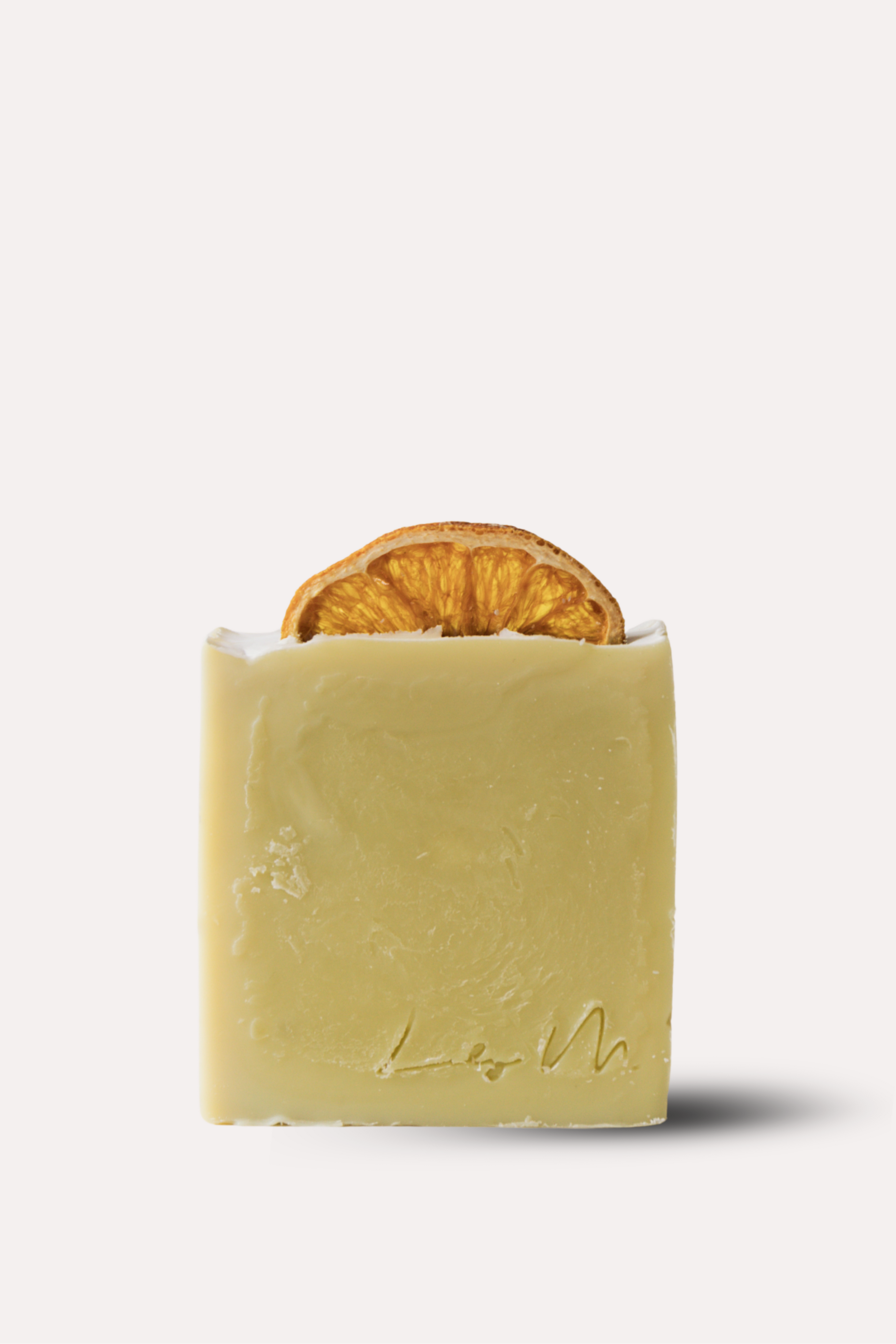 Bar of soap with a slice of orange inside on a white background