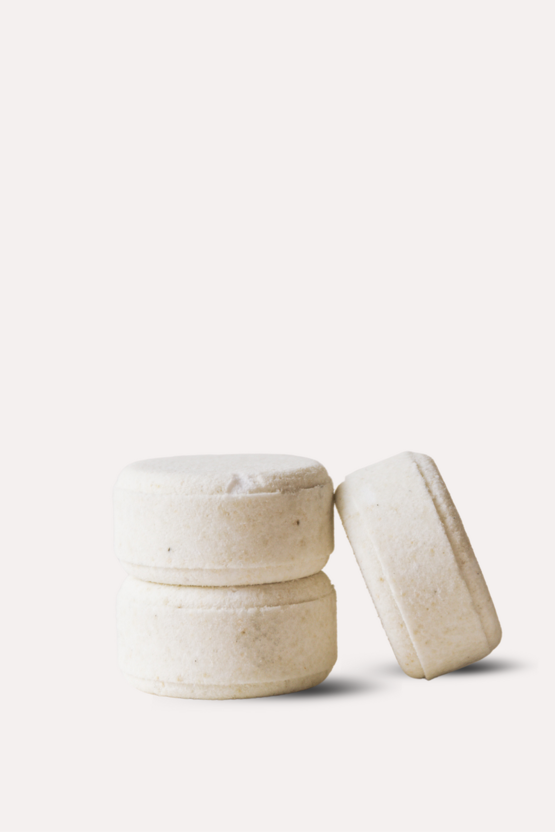 Three beige ceramic containers on a white background