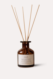 Brown glass diffuser bottle with wooden sticks on a white background