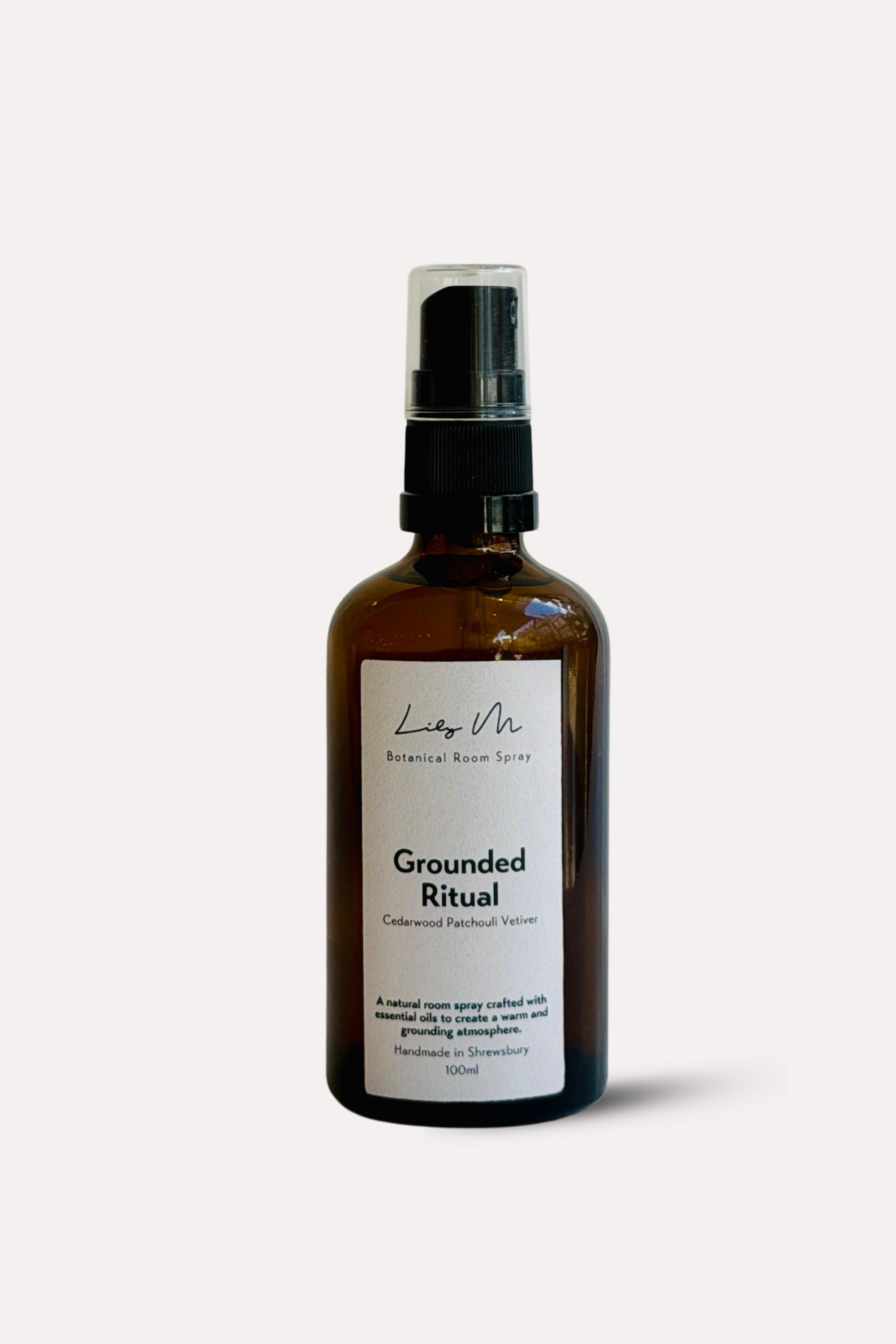 Brown spray bottle labeled 'Grounded Ritual' on a white background