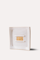 White jewelry box with a gold tag on a white background