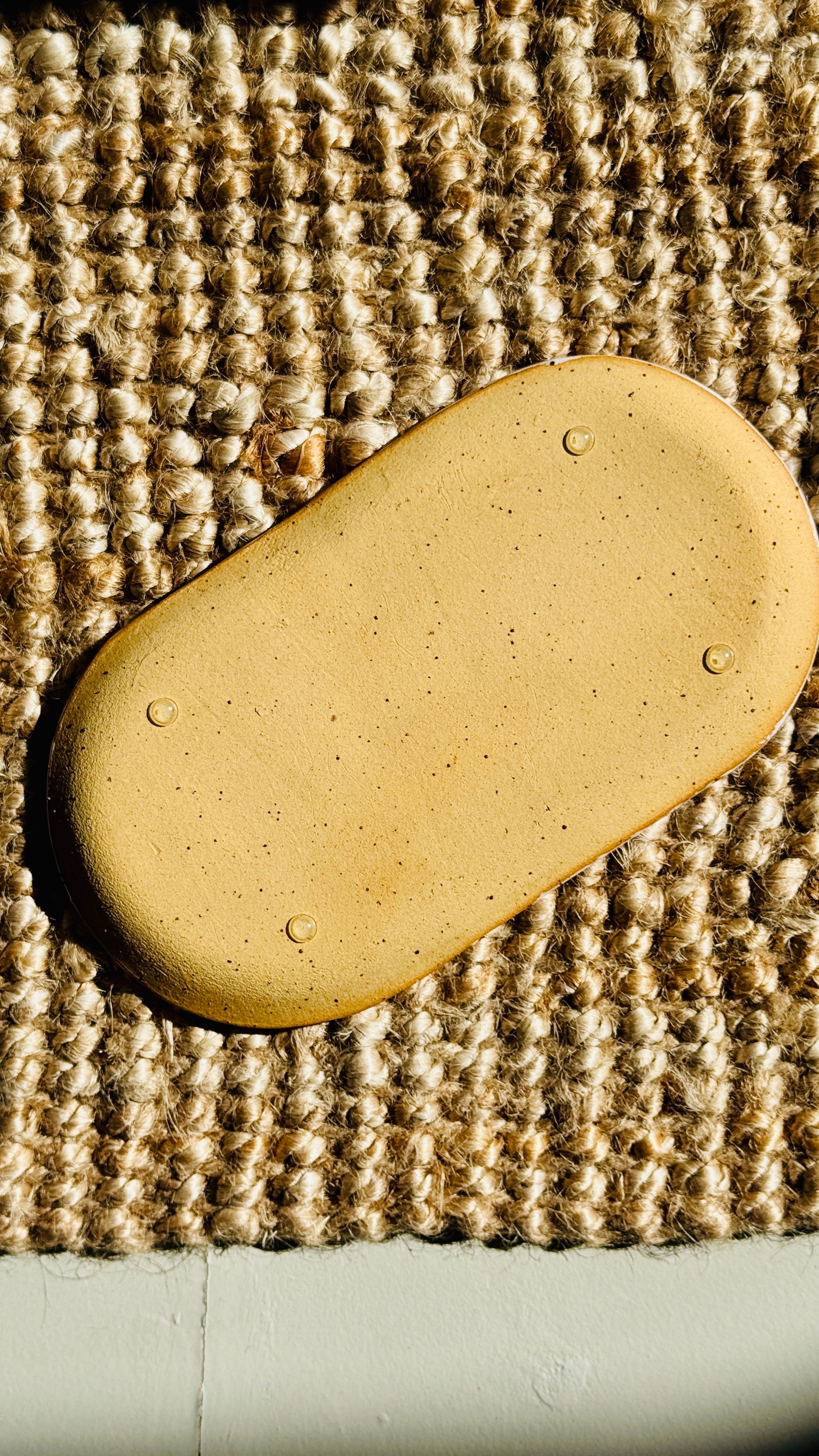 the base of the bottle tray on the hessian rug shows four rubber feet for stability that won’t scratch the surface 