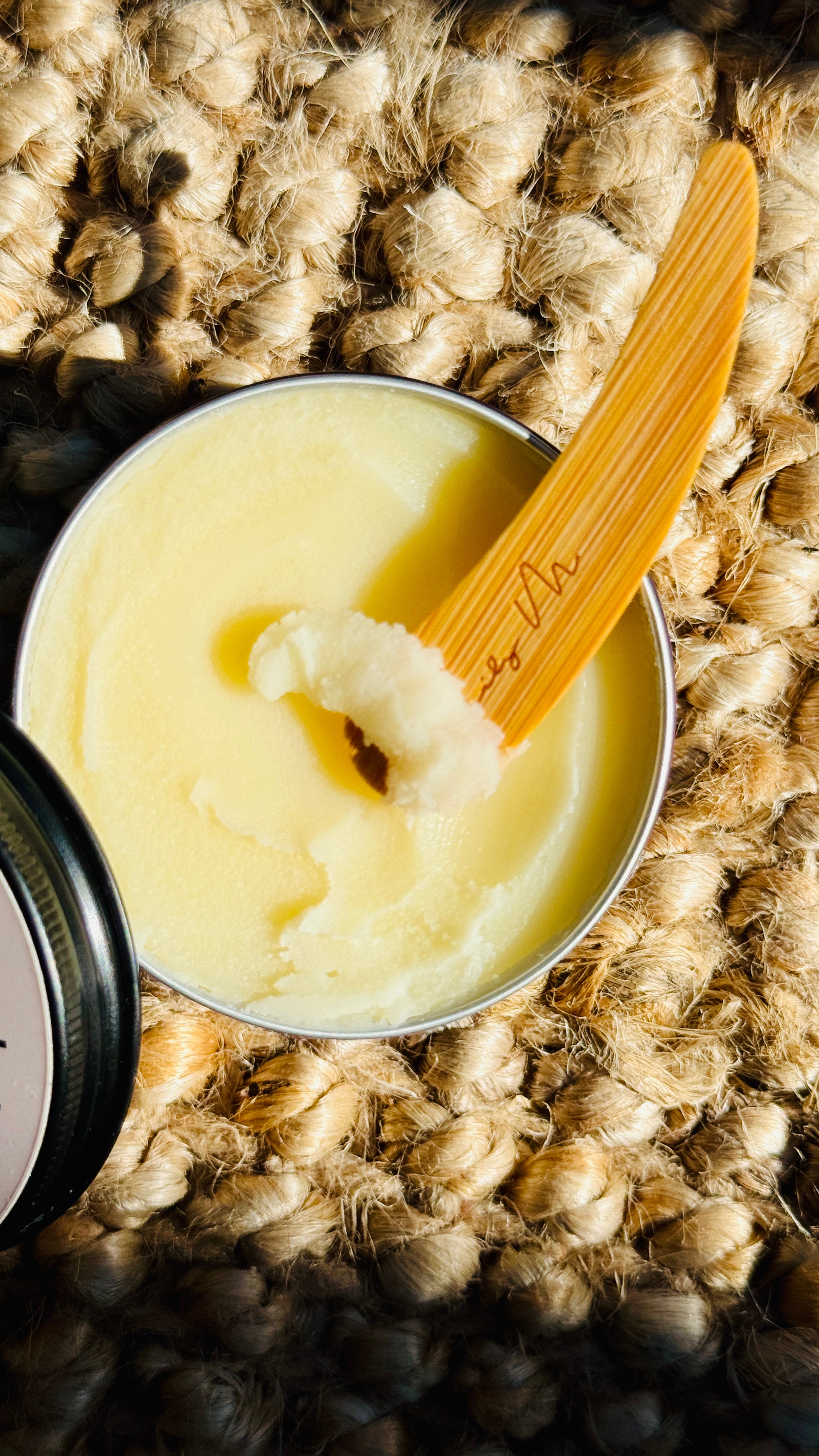 multi purpose balm with lid off and a wooden Lily M spatula, showing the texture