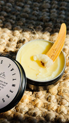 multi purpose balm with lid off and a wooden Lily M spatula, showing the texture - zoomed out image 