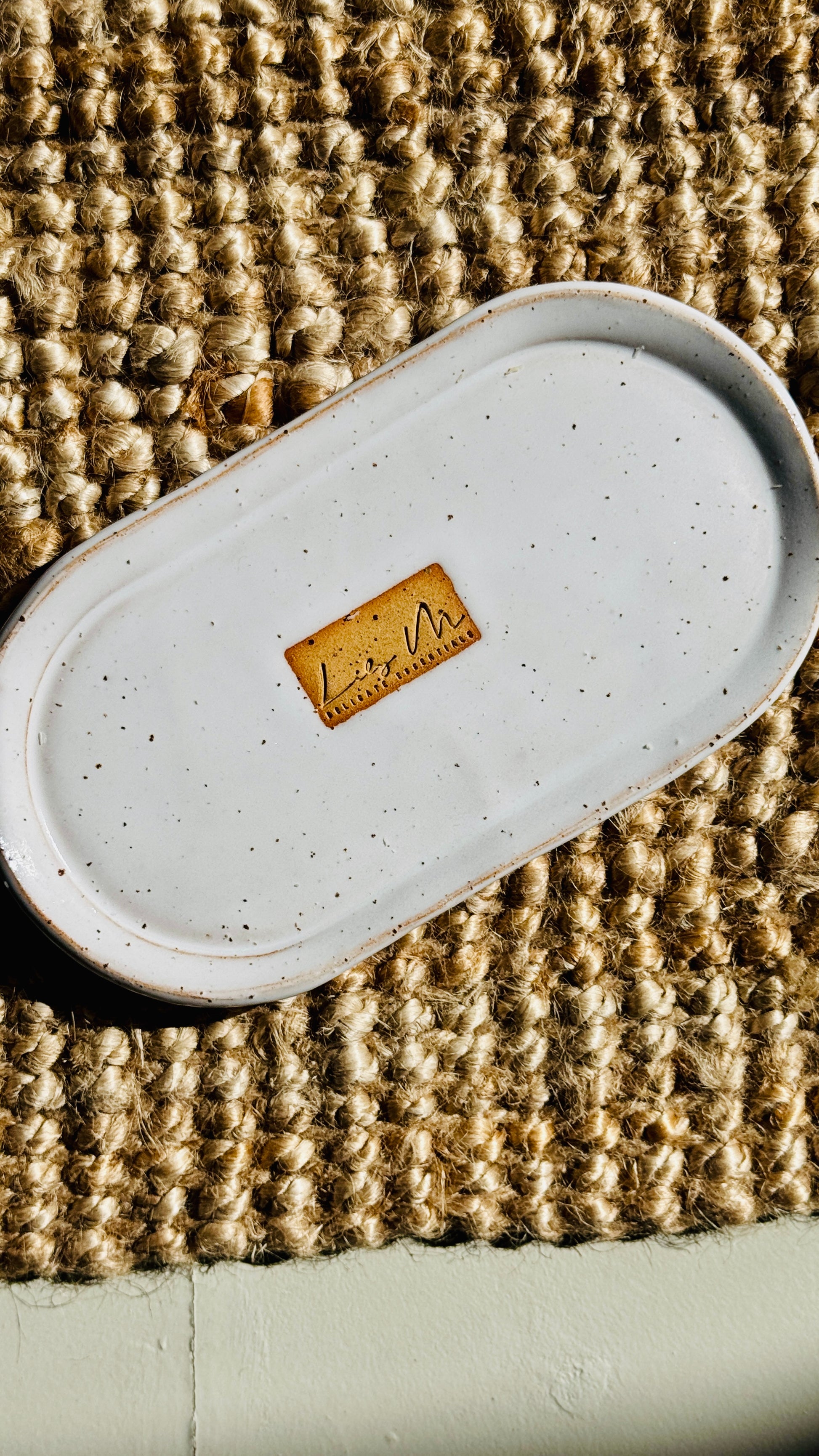 hand wash bottle tray on a hessian rug Lily M logo stamped in the the center of the tray unglazed, shows a brown rectangle around the logo