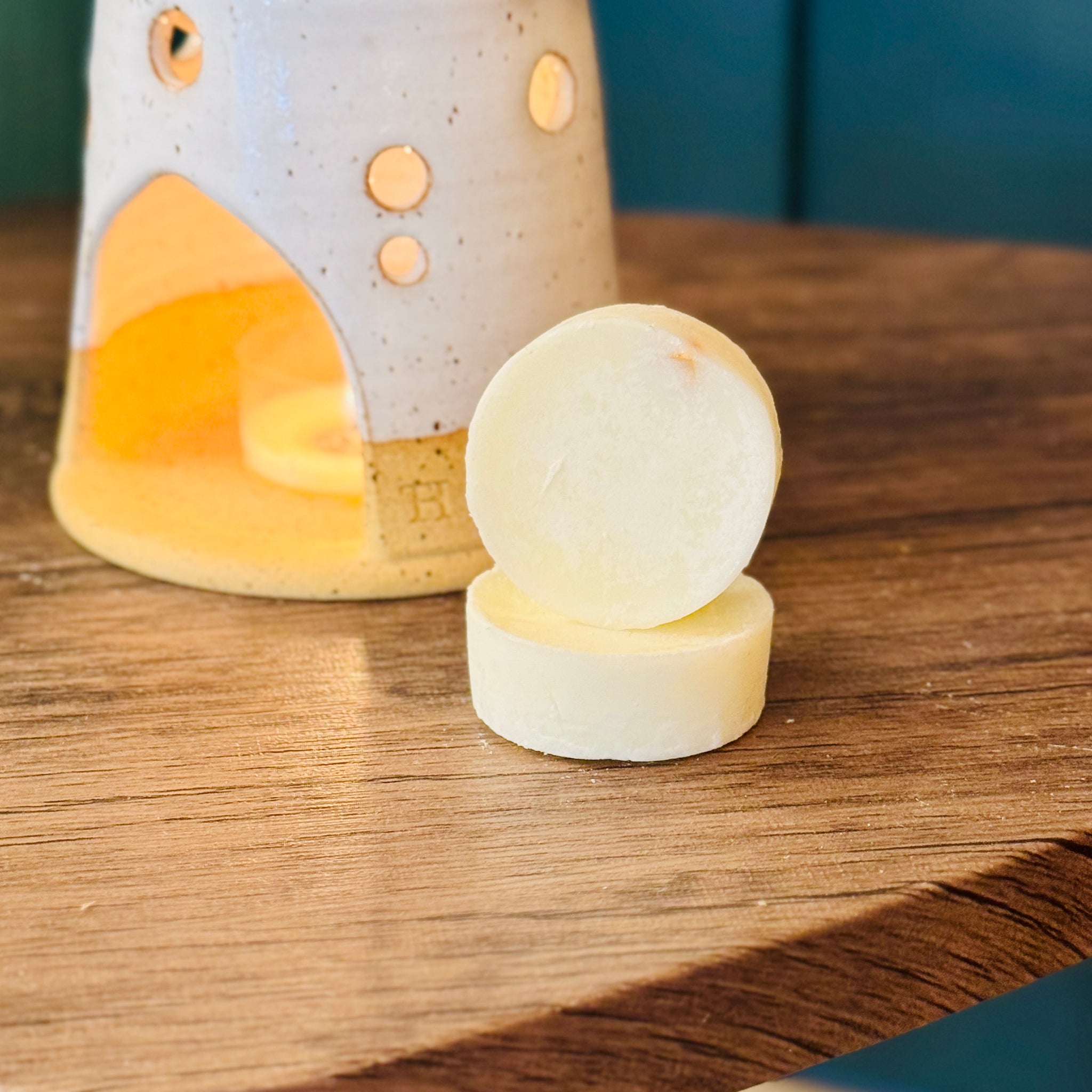 essential oil orange & lime wax melts with a wax melt burner in the background 